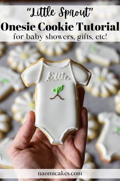 someone holding up a baby onesie cookie