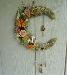 the moon is decorated with flowers and other things to hang on it's side