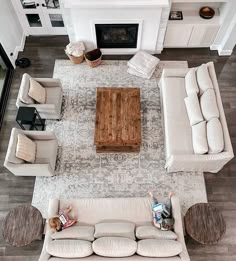 an overhead view of a living room with couches, chairs and a television on the wall