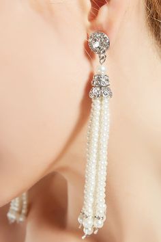 This sumptuous piece of jewelry features a retro-elegant yet slightly modern style that complements the lavish garments, reminiscent of the roaring 1920s. Features: Lustrous imitation pearls Rhinestone studded design 4.21 inch / 10.7cm long Dangling pearl tassels Elegant Beaded Bridal Earrings For Party, Elegant Beaded Bridal Earrings, Elegant Beaded Chandelier Earrings For Party, Elegant Pearl Jewelry For Vintage Events, Elegant Beaded Bridal Earrings For Formal Occasions, Elegant Beaded Pearl Chandelier Earrings, Elegant Pearl Beaded Chandelier Earrings, Elegant Beaded Pearl Earrings For Wedding, Elegant Beaded Jewelry For Vintage Events