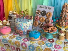 a table topped with lots of cakes and donuts