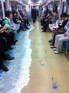 people are sitting on the subway with their feet in the water