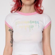 Vintage 70s white fitted tee with baby pink ringer trim, and a drippy chocolate syrup gradient graphic.  Measurements and Condition: Fits like: Women's XXS  Fabric: Feels like polyester or a blend Brand: Unknown, tag is faded Condition: Very good, with a couple faint light brown marks on the lower front half. Length: 15.5" Chest: 28" to 34" Waist: 26" to 32" - taken at the hem Sleeve opening: 6" to 10" around Shown on a 5'3" model with measurements of 31"-24"-34.5", usually wears a size petite extra small. See our FAQ for more info on sizing and condition ratings. Retro Fitted White Top, White Fitted Retro Top, Retro Style Fitted White T-shirt, Fitted Retro White T-shirt, White Fitted Retro T-shirt, Gradient Graphic, Bebe T Shirt, Fitted Crop Top, Graphic Baby Tee