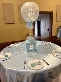 a table set with plates, silverware and a clear balloon on top of it