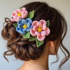 a close up of a woman's hair with crocheted flowers in it