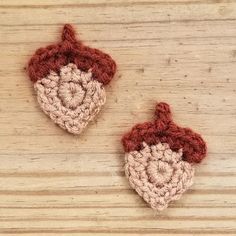 two crocheted ornaments sitting on top of a wooden table