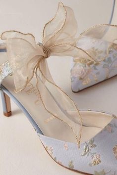 a pair of high heeled shoes with bows on the toe and heels that are decorated with flowers