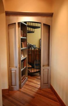 an open door leading to a room with bookshelves and stairs in it,