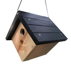 a wooden bird house hanging from a string