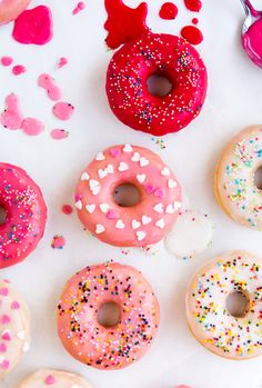 there are many different donuts with sprinkles and hearts on the table