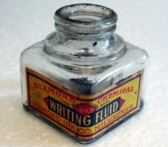 an old fashioned writing fluid bottle sitting on a table