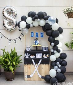 a balloon arch with hockey themed decorations and balloons