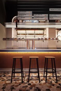 three stools in front of a bar