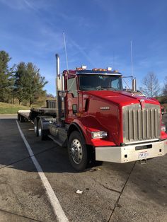 a red semi truck parked in a parking lot