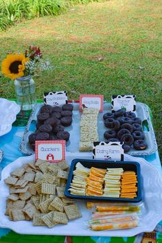 a table topped with lots of snacks on top of a blue and white cloth covered table