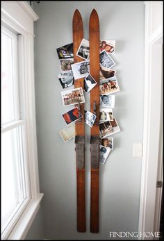 a wall mounted ski rack with pictures and photos on the bottom, hanging from it's sides