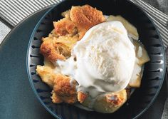 a bowl filled with ice cream on top of a blue plate next to a spoon