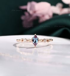 an engagement ring with a blue topazte surrounded by three white diamonds on a table