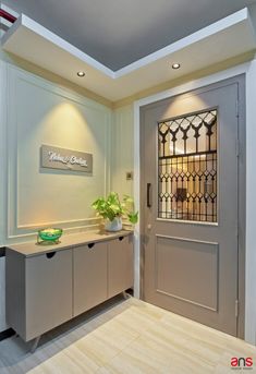 an entry way with a glass front door and metal sideboard on the other side