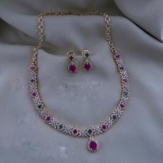 Cubic Zirconia Diamond Necklace Ruby Silver Look Chain Necklace AD Jewelry Set Indian Wedding Bridal Set Designer Necklace Gift Ideal  Color :    Gold And Silver    Gemstone  :   Cubic Zirconia / Quartz Stone   Product Type  :  Necklace / Earring  Product Details : Our Jewelry is handcrafted by traditional artisans. Each piece is individually double checked for quality purposes.  Ideal Gift Idea: Perfect beautiful & memorable gift for you and your loving wife, girlfriend, sister, aunt, daughter and mom/mother/mummy. These are very skin Friendly. The plating is Non- Allergic and safe for all Environment. Made of long lasting brass metal, good quality. Hand finished. Raw material - Artificial Jewelry, CZ Diamonds Necklace Necklace Length =  8 Inches Earrings Length =   1.5 Inch Occasion: Per Cubic Zirconia Bridal Necklace With Stones For Wedding, Wedding Bridal Necklace With Cubic Zirconia Stones, Multicolor Crystal Necklace For Wedding, Cubic Zirconia Necklace With Sparkling Stones For Receptions, Multicolor Cubic Zirconia Necklace For Formal Events, Multicolor Cubic Zirconia Necklace For Formal Occasions, Multicolor Jeweled Bridal Necklace For Wedding, Elegant Multicolor Necklaces For Wedding, Elegant Multicolor Wedding Necklaces