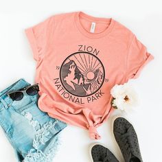 Looking for a cute versatile top to wear? Make sure to grab one of our Graphic tees! This soft and comfortable graphic tee is the perfect top for any outfit. It can be paired with biker shorts, jeans, or even a simple skirt/dress! This tee is true-to-size, so be sure to order your regular t-shirt size! If you are looking for a more oversized look, make sure to size up! Summer Tops With Logo Print, Outdoor Graphic Tee With Short Sleeves, Summer Tri-blend Tops With Logo Print, Outdoor Short Sleeve Graphic Tee, Spring Rodeo Graphic Tee, Desert Graphic Tee, Graphic Print Short Sleeve T-shirt For Travel, Tiny Tank, Trending Graphic Tees