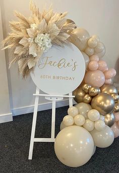 a birthday sign surrounded by balloons and flowers