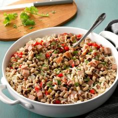 a white bowl filled with rice and beans next to a cutting board on top of a table