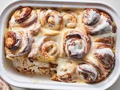 baked cinnamon rolls in a baking dish with icing on top, ready to be eaten