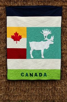 the canadian flag has been made into a quilted wall hanging with a moose on it