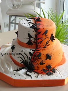 two tiered cake decorated with black and orange designs