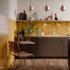 a kitchen with wooden flooring and brown cabinetry next to a dining room table