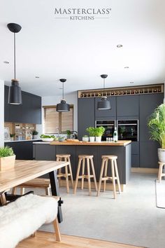 a modern kitchen with grey cabinets and wooden stools