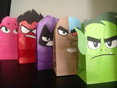 an assortment of paper bags with cartoon characters on them, all lined up in different colors