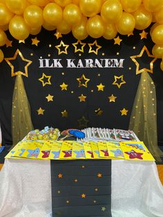 the table is set up with yellow balloons and stars on it, along with a sign that says i like karnem