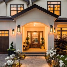 the front entrance of a house with lights on