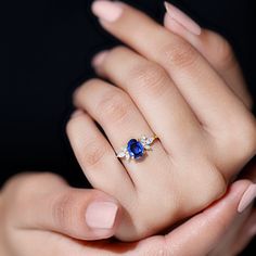 a woman's hand holding a blue and white ring