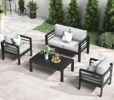 an outdoor living room with grey furniture and plants