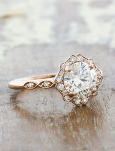 a close up of a diamond ring on a wooden surface