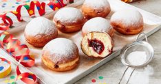 pastries with jam are on a tray next to confetti and streamers