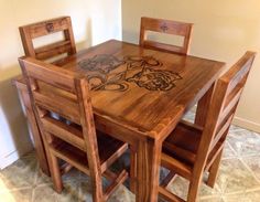 a wooden table with four chairs sitting next to each other on tiled flooring in front of a wall