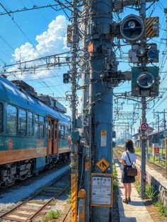 a woman is waiting for the train to stop on the tracks in front of her