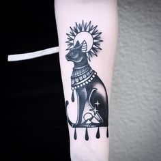 a black and white cat tattoo on the arm