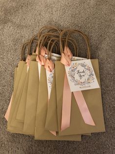 there are many brown bags with pink ribbons on them