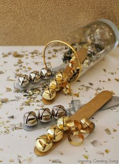 three pairs of gold and silver earrings sitting on top of a table next to a corkscrew