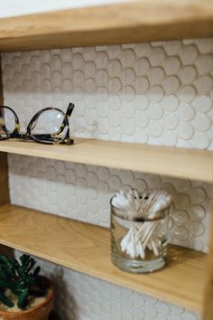 a pair of glasses sitting on top of a wooden shelf