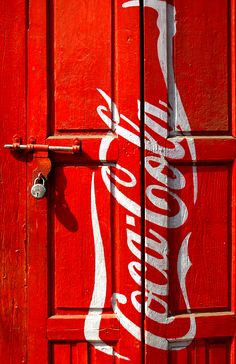 the door is painted red and white with coca - cola's logo on it