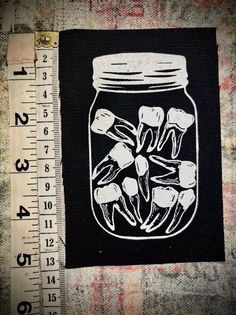 a mason jar filled with flowers next to a ruler