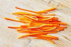 sliced up carrots sitting on top of a wooden cutting board