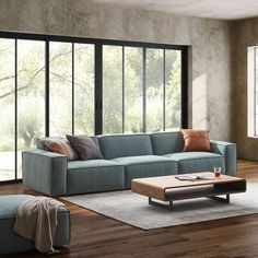 a living room filled with furniture next to a large glass wall window on top of a hard wood floor