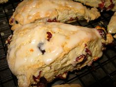 scones with icing and cranberries on a cooling rack